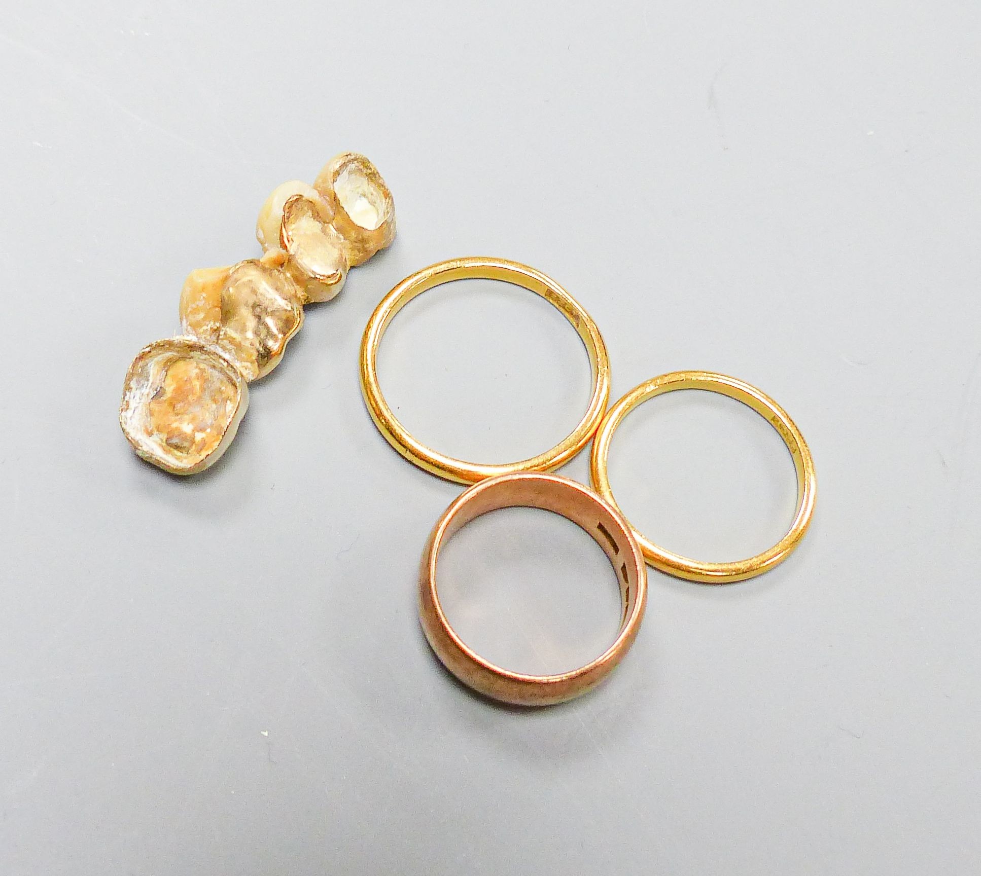 Two 22ct wedding rings, 5.7 grams, a 9ct rose gold wedding band 4.6 grams and four gold-mounted teeth.